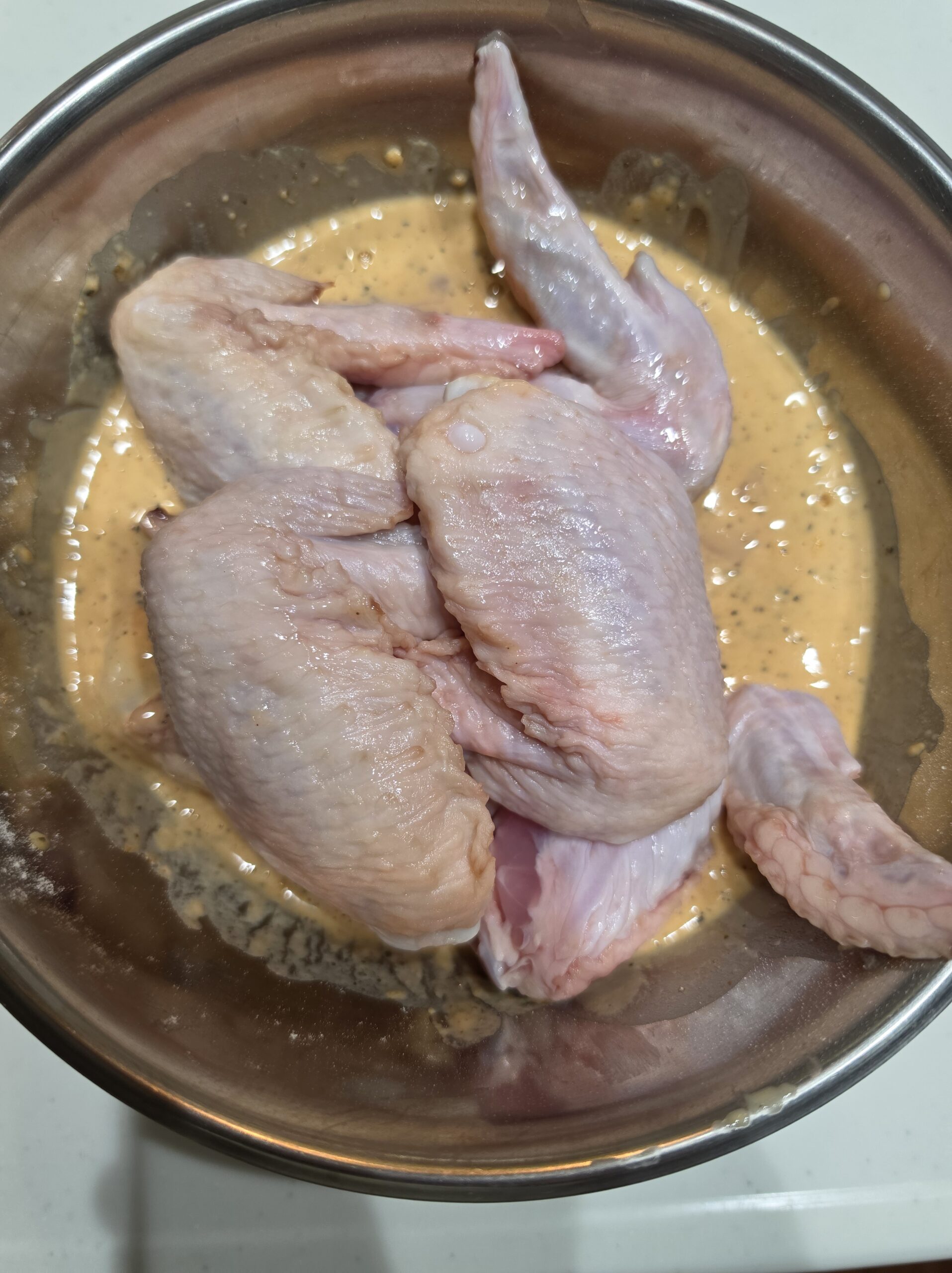 ボウルでチキチキボーン粉の水溶き衣に漬け込んだ手羽先